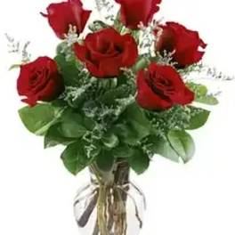 Bouquet of red roses with greenery in a clear vase