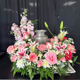 Pink and white floral arrangement around a silver urn