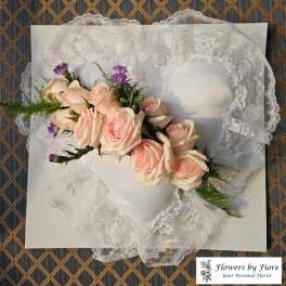 Lace heart-shaped pillow with a pale pink rose corsage
