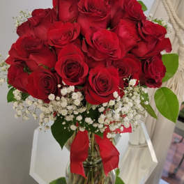 Bouquet of red roses with white baby's breath in a glass vase