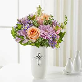 Pastel bouquet in a white vase with a cross emblem