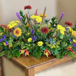 Colorful floral arrangement with yellow, purple, and red blooms on a wooden table