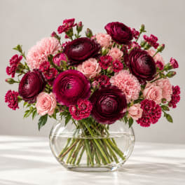 Bouquet of burgundy and pink flowers in a clear glass vase
