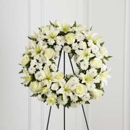 White floral wreath on a black stand