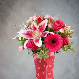 Pink roses and lilies arranged in a pink cowboy boot vase