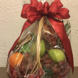 Fruit basket wrapped in clear cellophane with a large red bow