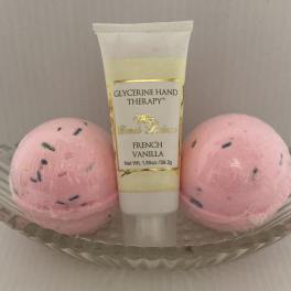 Hand therapy tube in a glass dish with two pink bath bombs
