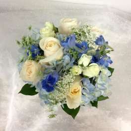Bouquet of cream roses and blue flowers with pale hydrangea