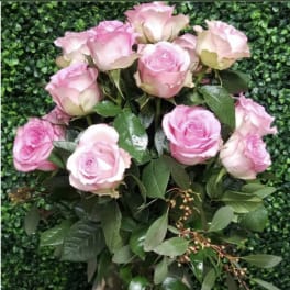 Pink roses arranged in a clear glass vase