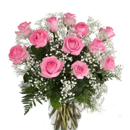 Pink roses arranged in a clear glass vase with baby's breath