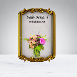 Mixed pink and peach flowers in a clear glass jar