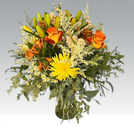 Mixed bouquet of orange and yellow flowers in a glass vase