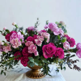 Pink roses and carnations in a gold pedestal vase