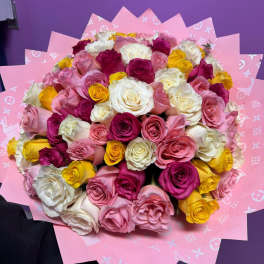Bouquet of pink, white, and yellow roses wrapped in pink paper