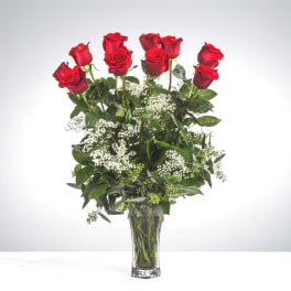 Tall bouquet of red roses in a clear glass vase