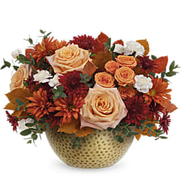 Peach roses and orange mums in a textured gold vase