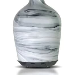 Marble-patterned glass essential oil diffuser with a narrow neck and dark base