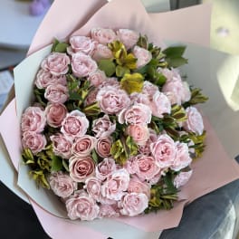 Bouquet of pale pink roses and yellow alstroemeria wrapped in pink paper