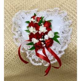Heart-shaped bouquet of red and white flowers with lace trim and red ribbon