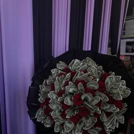 Bouquet of red roses mixed with folded dollar bills