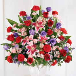 Large mixed bouquet in a white vase with red, pink, and purple flowers