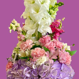 Basket arrangement of white gladiolus, pink carnations, and lavender hydrangeas