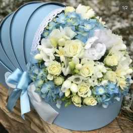 Blue and white bouquet with roses and hydrangeas in a round hatbox