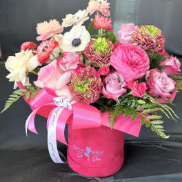 Pink and white mixed bouquet in a bright pink hat box with ribbon