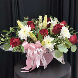 Red roses and white lilies with white chrysanthemums in a pink gift box