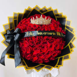 Large bouquet of red roses with a black ribbon and gold crown