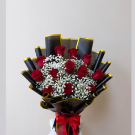 Bouquet of red roses with white baby's breath in black and gold wrap