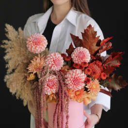 Pink and peach floral arrangement in a round pink box