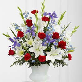 Red roses, white lilies, and purple flowers in a white vase