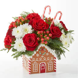 Christmas bouquet in a gingerbread house container with red roses and white daisies