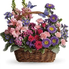 Basket of pink and purple flowers with butterfly accents