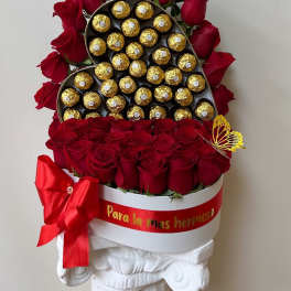 Red roses arranged around a heart-shaped box of chocolates