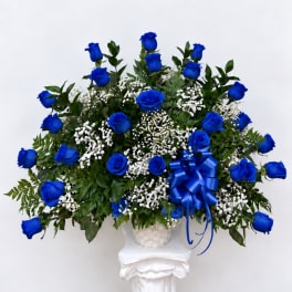 Blue roses in a white basket with a blue ribbon bow