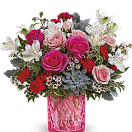 Pink and white rose bouquet in a pink glass vase