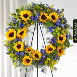 Sunflower wreath with blue flowers on a black stand