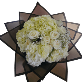 Round bouquet of ivory roses and hydrangeas wrapped in layered dark geometric paper