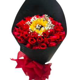 Bouquet of red roses with a sunflower center in black wrap