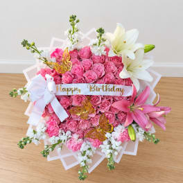 Pink rose bouquet with white lilies and a birthday ribbon