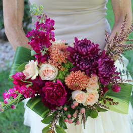 Bride holding a bouquet of magenta and peach flowers