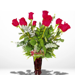 Red roses arranged in a tall burgundy vase
