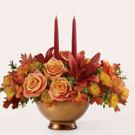 Autumn floral centerpiece with red candles in a gold bowl vase