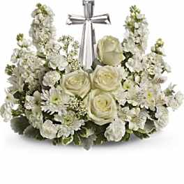 White floral arrangement with a silver cross centerpiece
