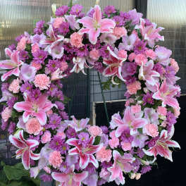 Large pink and purple floral wreath on a stand