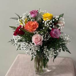 Mixed roses with baby's breath in a clear glass vase