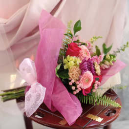 Pink mixed bouquet wrapped in translucent paper