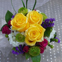 Yellow roses with purple and white flowers in a small bouquet